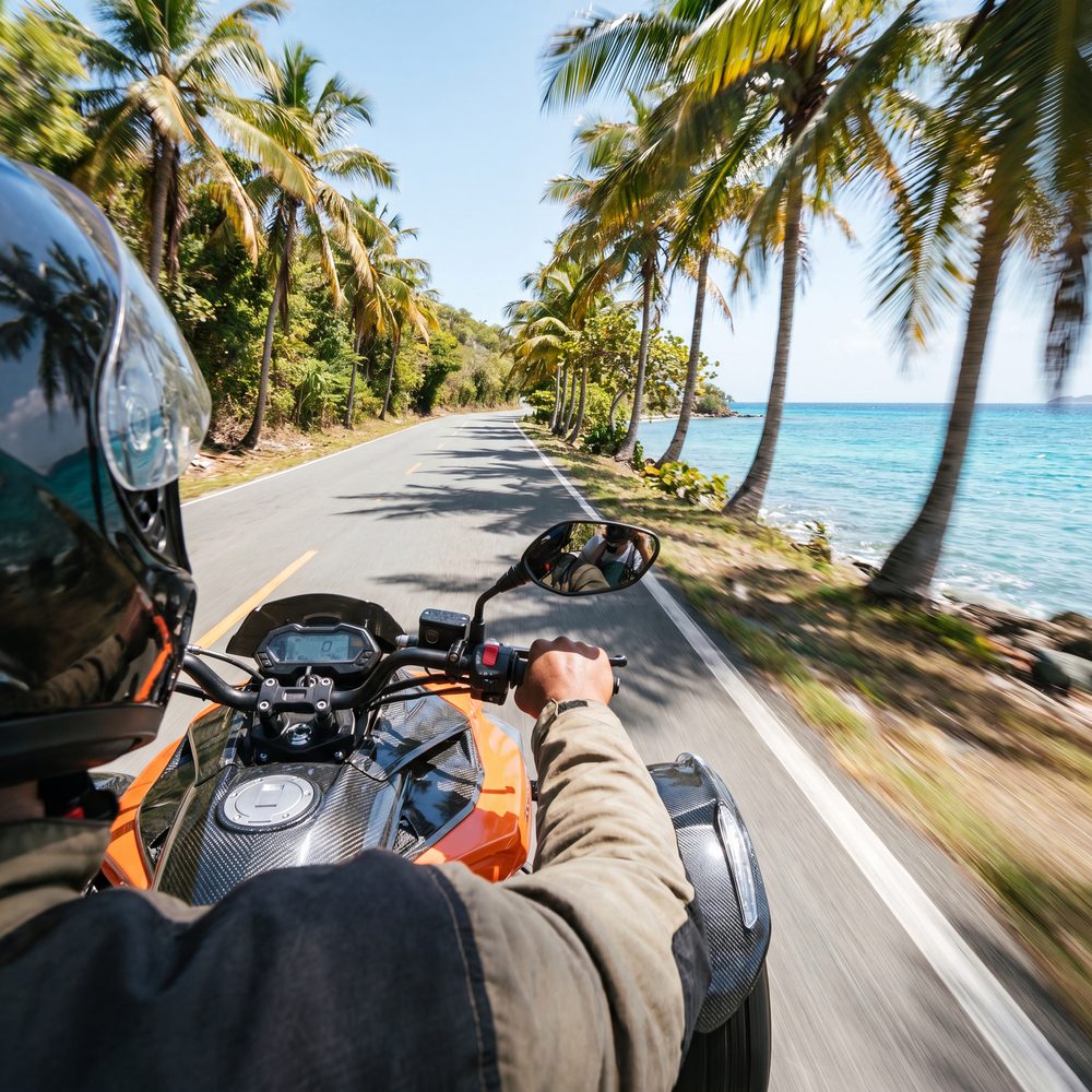 Rider's point of view cruising a scenic coastal road on a trike